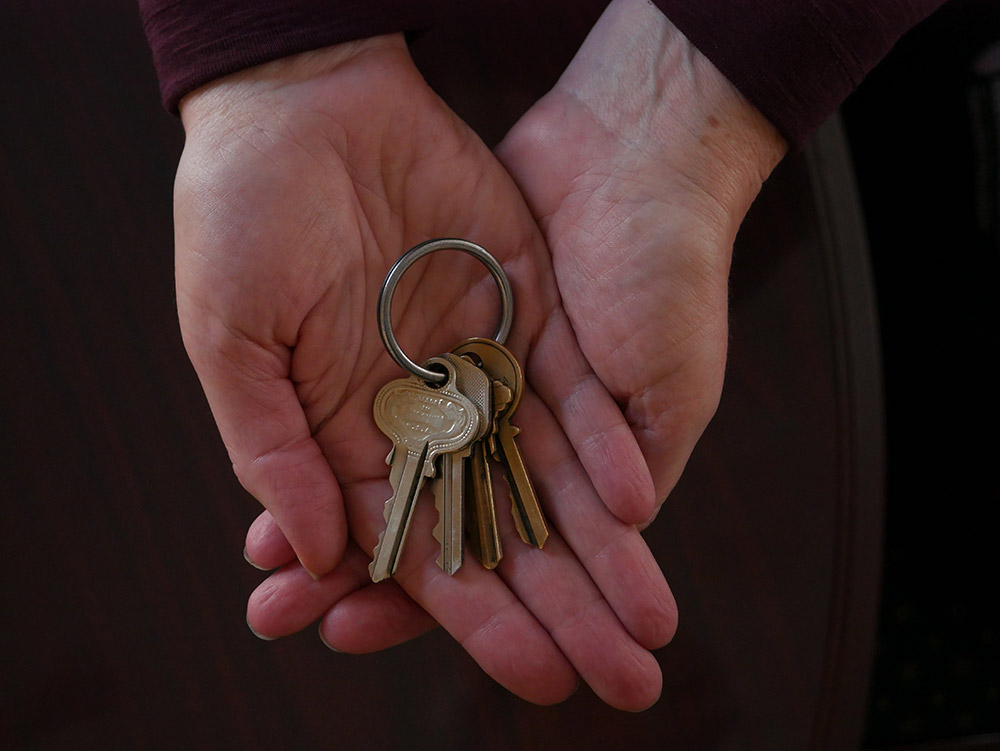 Hands holding house keys.